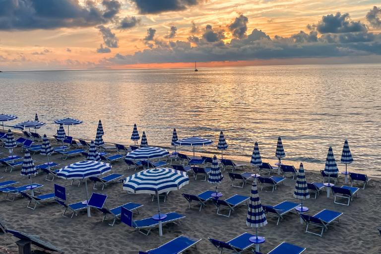 beach at sunset with umbrellas and chairs