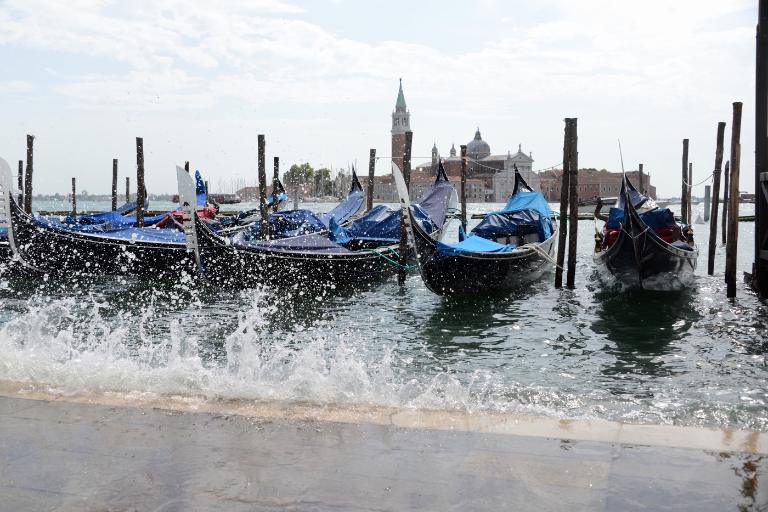 gondolas docked by a canal in venice