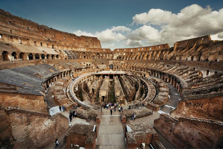 Colosseum Tickets & Tours 2 a group of people inside the Colosseum overlooking the lower floor