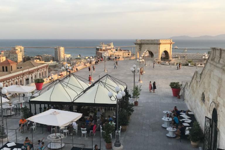 a group of people sitting at tables and chairs on a terrace