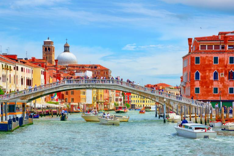 a bridge over water with boats and buildings in the background