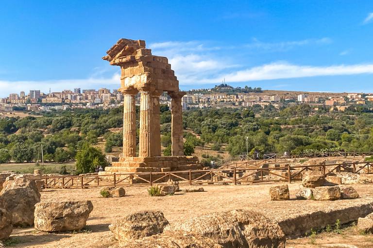 a stone structure with a city in the background