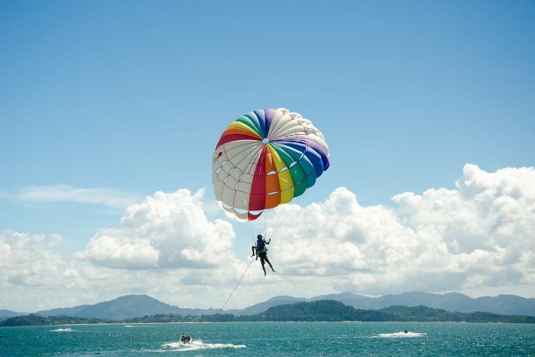 a person on a parachute above water